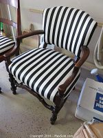 Front view showing striped upholstered armchair with walnut finish frame and turned legs