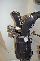 Front view of the golf bag with multiple golf clubs including clubs with Cleveland covers