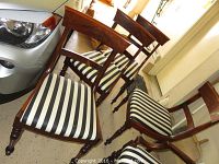 Group of five chairs viewed at an angle showing frames, upholstery and turned front legs