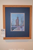 Full view of framed acrylic painting depicting snowy urban scene with church-like building and city skyscrapers.