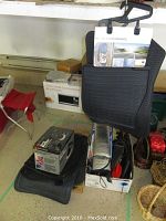 Full lot view showing floor mats, boxed Black and Decker buffer, car vacuum, windshield sun screen in box and other miscellaneous items