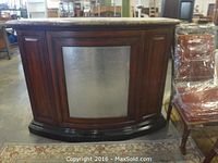 Front view of closed curved wood cabinet with silver accent panel