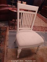 Front view of a single white wooden dining chair with upholstered seat.