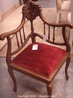 Full view of the wooden corner chair showing carved frame and red upholstered seat