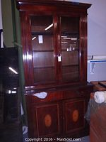Full view of the china cabinet showing its two-piece design, with glass doors on the hutch and solid wood lower cabinet with inlays.