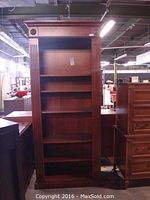 Full frontal image of the tall Domain wooden bookshelf showing its carved wood features and five shelves.