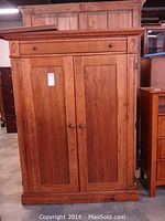 Front view of the Romweber wood entertainment center showing closed doors and drawer