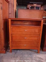 Full frontal view of the dresser showing three drawers and open shelf.