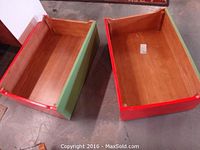 Pair of wood children organizers, one painted red and one painted green, showing top view of interior and exterior with natural wood finish inside.