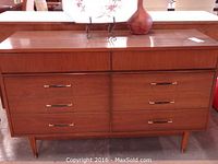 Front view of entire dresser showing six drawers, wood veneer finish and tapered legs