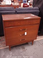 Full front view of mid-century dresser showing three drawers and tapered legs