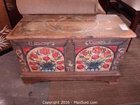 Front view showing overall painted floral panels and stylized bird