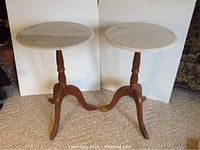Two occasional tables with white marble tops and brown wooden tripod bases