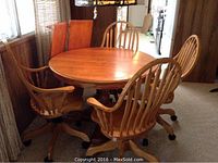 Full view of round oak pedestal table with four chairs