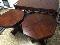View of tops of two octagon end tables and sofa table showing chevron patterned wood tops and carved drawer fronts.