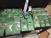 Overview of pewter ornaments attached to green informational cards laid out on two chairs