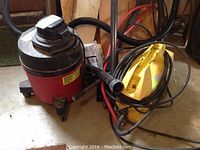 Photo showing both items, Shop-Vac wet/dry vacuum and Karcher pressure washer, with attached hoses and cords.