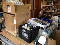View of the lot items arranged on a table including box with styrofoam hats, plastic cups in crate, trays with letters and hangers.
