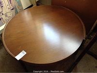 Top view of round wooden coffee table showing the surface and wood grain with minor scratches and scuffs