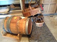 Wooden whisky barrel on its stand with tool basket and horseshoes on floor