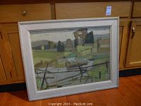Full view of framed painting leaning against cabinet showing landscape composition