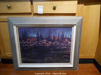 Framed print depicting Algonquin landscape with dark tones, rocky details, and tall thin trees under blue and reddish skies with artist signature visible.