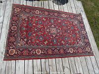 Full view of rug on wooden deck showing overall design and condition