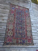 Full view of rectangular rug on wooden deck