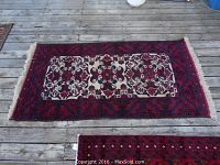 Full view of rectangular rug laid on a wooden deck