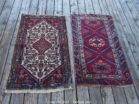 Both rugs side by side on wood deck showing overall patterns and condition