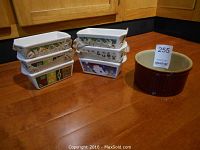Set of six rectangular baking dishes stacked in two columns with different holiday-themed prints alongside one brown round baking dish.
