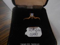 Ring in a jewelry box with a tag reading '10K gold opal' indicating the material and gemstone.