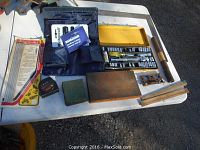 Variety of tools laid out on a table including Husky socket set, Mastercraft cutters, rifle cleaning kit, wooden and metal tools.