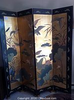 Front side with gold background and painted lotus flowers, reeds and birds across four hinged panels