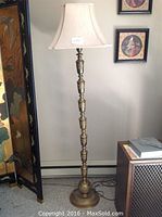 Full height view of the brass floor lamp with fabric shade.