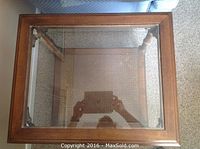 Top view of one end table showing the oak wood frame and clear glass top.
