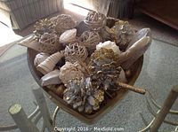 Photo showing the triangle gold bowl filled with assorted natural and gold-accented potpourri including pinecones, woven balls, and dried botanicals.