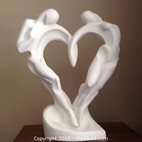 Front view of the white acrylic sculpture depicting two figures forming a heart shape.