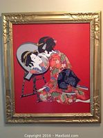 Framed artwork showing an Asian geisha girl printed on red fabric background in gold-toned frame.