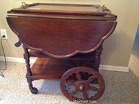 Front view of tea cart with side trays folded down and removable tray on top