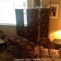 The three panel folding fabric screen with black metal frame and animal print fabric panels shown behind the bench and stool.
