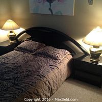 Full view of assembled queen bed frame with curved black lacquer headboard, mattress and two matching end tables