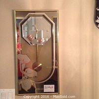 Full frontal image of the pendulum wall clock showing mirrored octagonal clock face, brass pendulum, gold frame, and etched floral mirror design on bottom section.