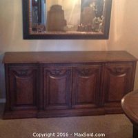 Front view of the oak wooden sideboard showing four closed cabinet doors with carved details.