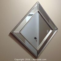 Diamond-shaped 30x30 wall mirror with decorative beveled edges and mirrored frame hung on wall.