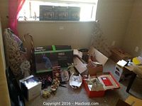 Wide shot showing the assortment of Christmas decorations and boxed lighting items on a carpeted floor near window.