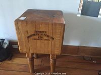 Front view of wooden butcher block showing stenciled company name and overall shape