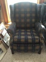 Front view of blue plaid upholstered wing back La-Z-Boy recliner chair.