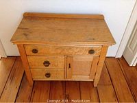 Front view of washstand showing three drawers left and cupboard door right