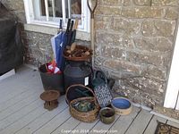 Photo showing the entire lot including cast iron pot, umbrellas, milk can, basket, watering can, dog bowl, and small decorative iron piece.
